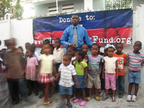 Pastor Dominique with children in Waney, Carrefour, Haiti Relief Fund donated clothing, shoes, and stuffed animals toys for Christmas 2010. 